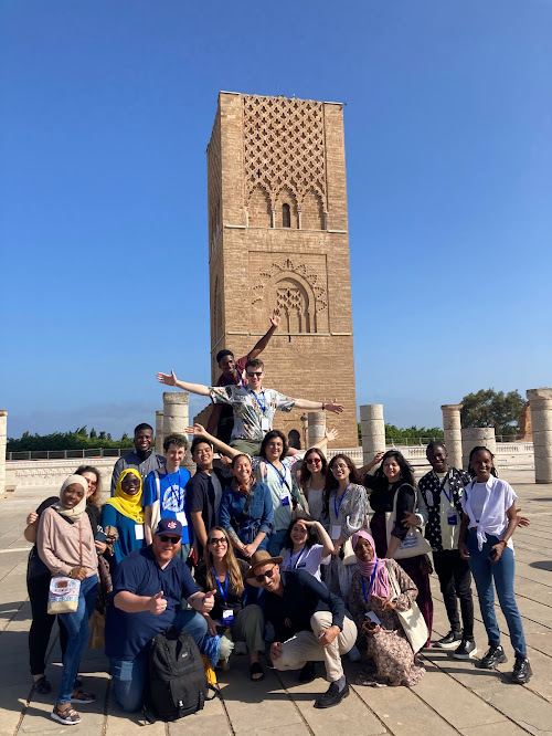 A Group Of People Pose In Front Of An Historical Site In Morocco