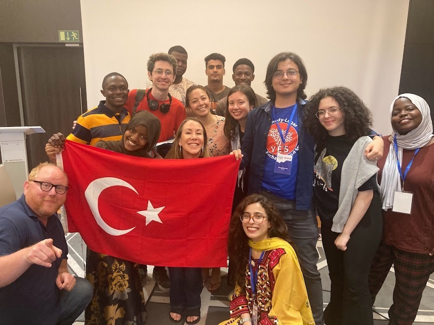 A Group Of People Pose With The Turkiye Flag