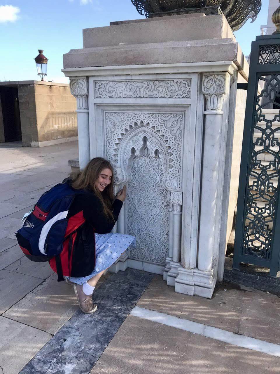 Chloe kneeling by a wall