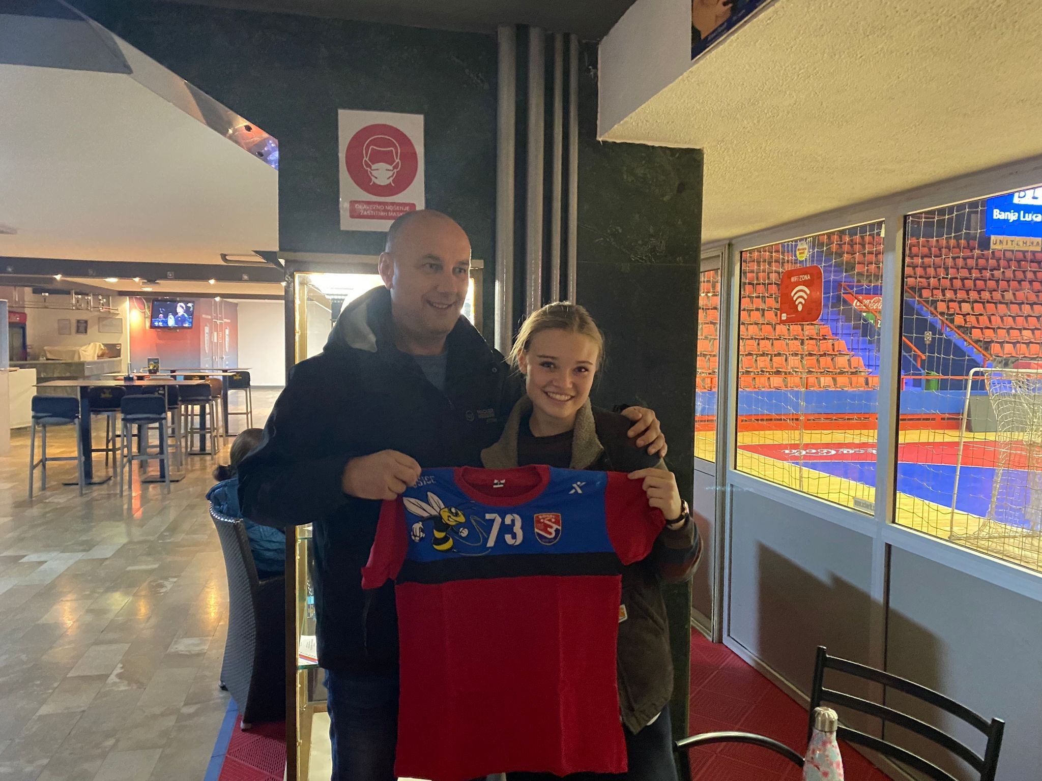 YES Abroad student, Clara standing next to her host dad and holding a Handball jersey