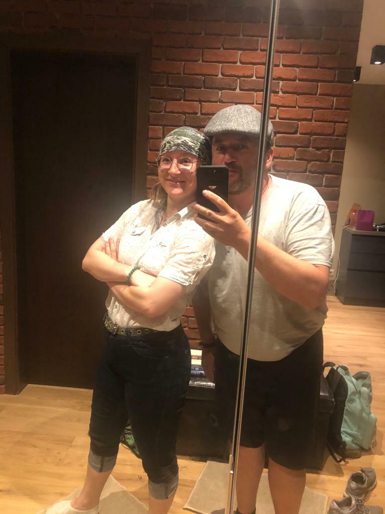 Peri taking a mirror selfie with her host dad wearing white shirts and hats