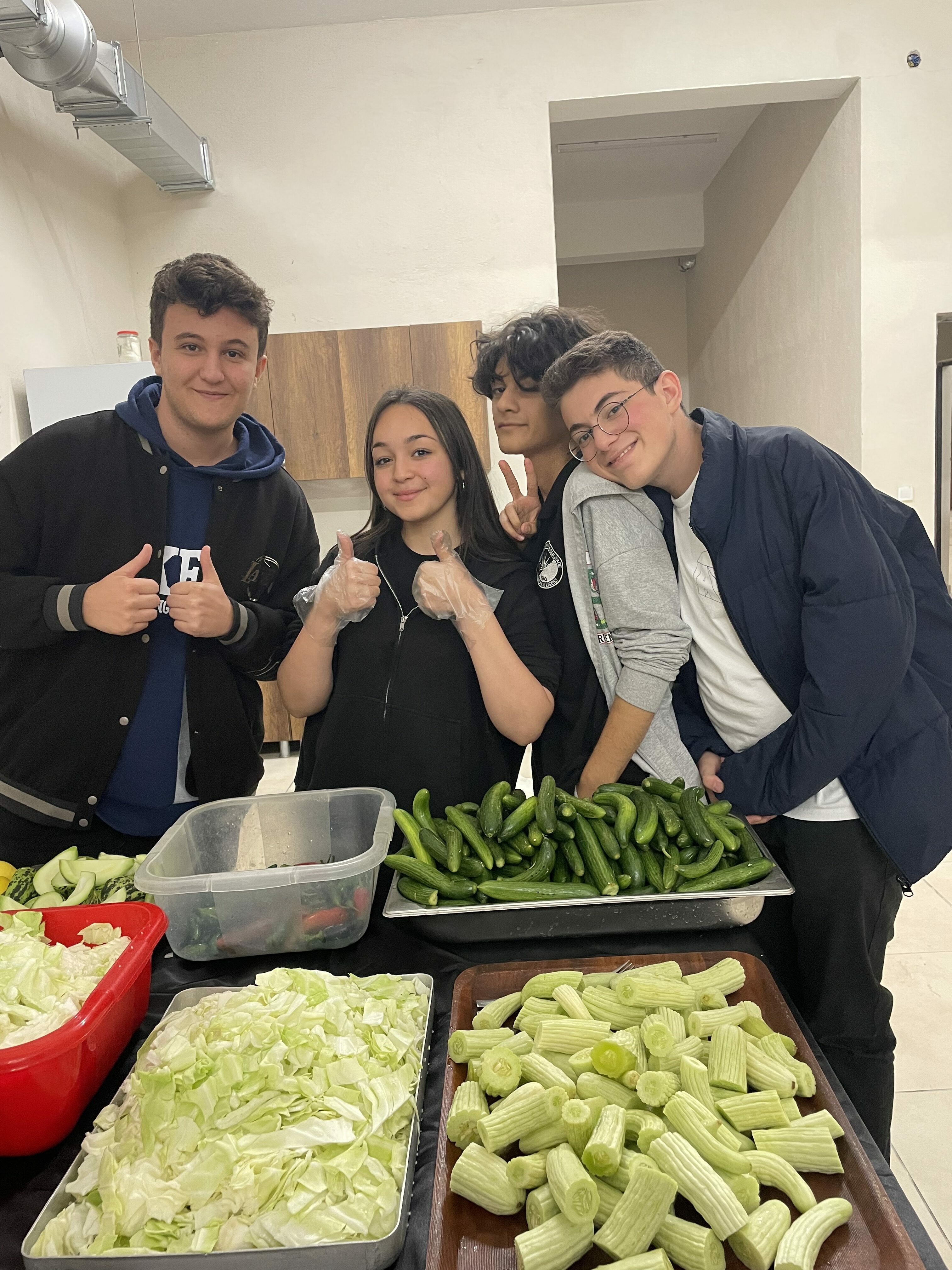 Martine and 3 classmates smiling over food they are preparing
