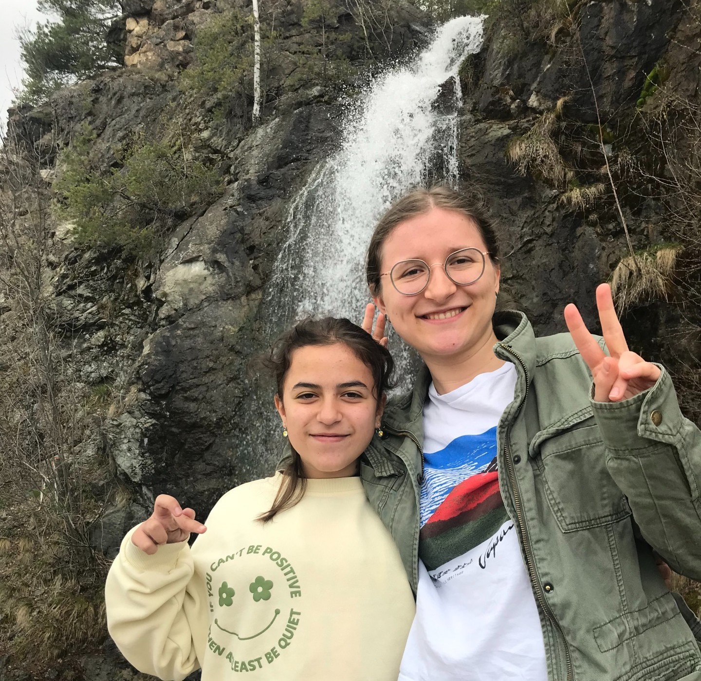 Peri Posing With Host Sister In Front Of A Waterfall