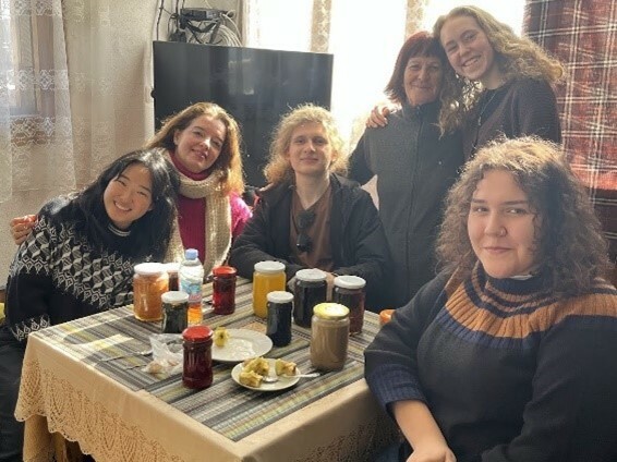 A group of students smiling around a table filled with jams