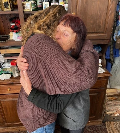 A grandmother and a teen girl embracing
