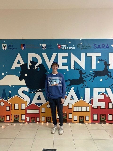 Student smiling in front of the race banner
