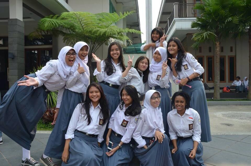 Victoria posing outside with a group of 10 other students at her host school