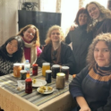 A group of students smiling around a table filled with jams