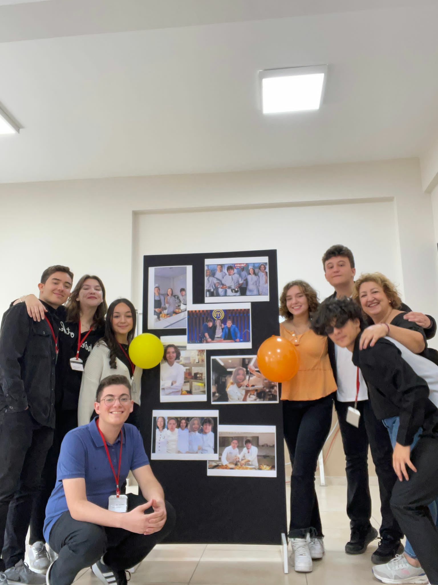 Martine and her classmates smiling in front of a poster board with photos