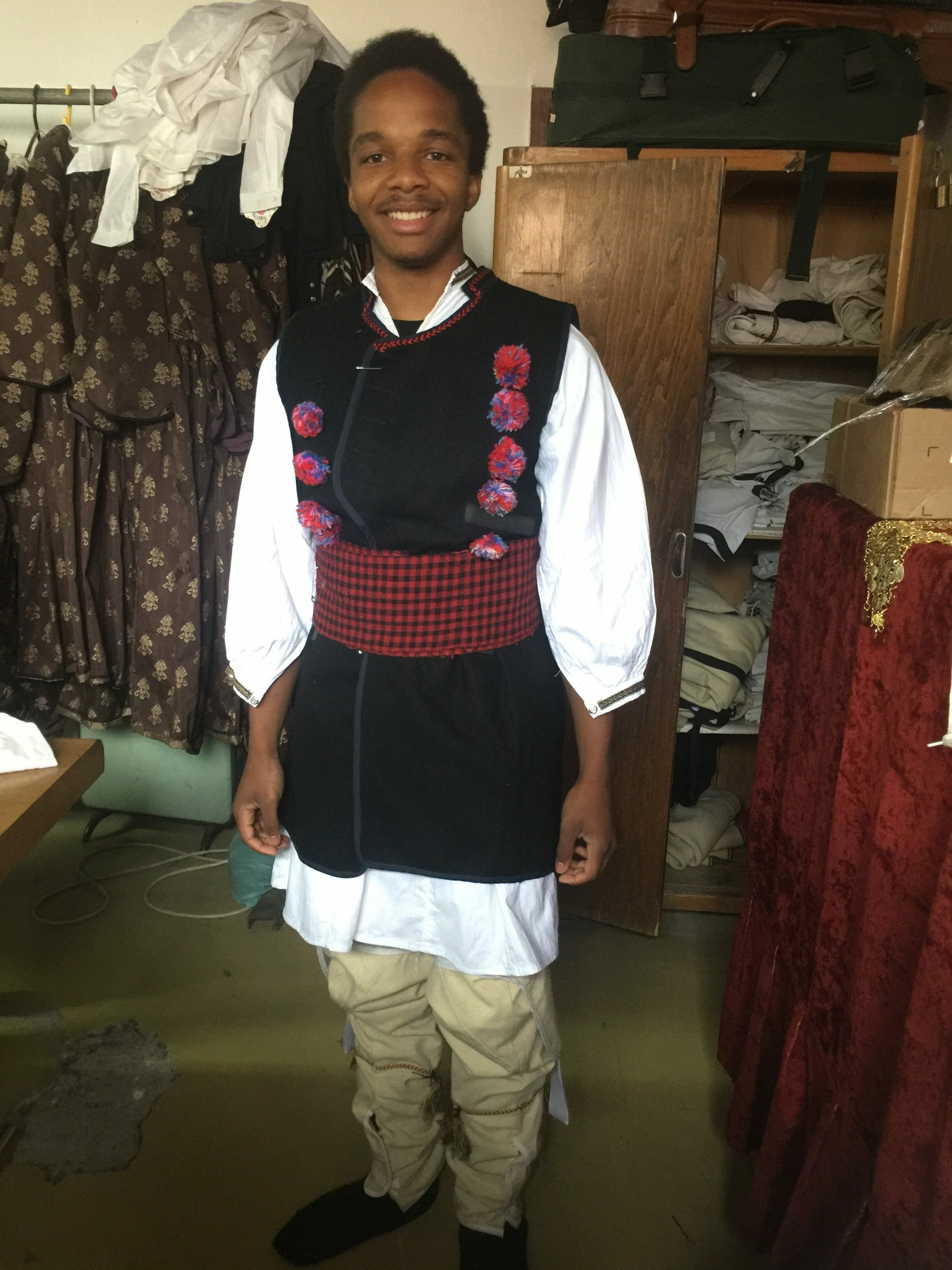 Maxwell smiling in traditional Macedonian clothes